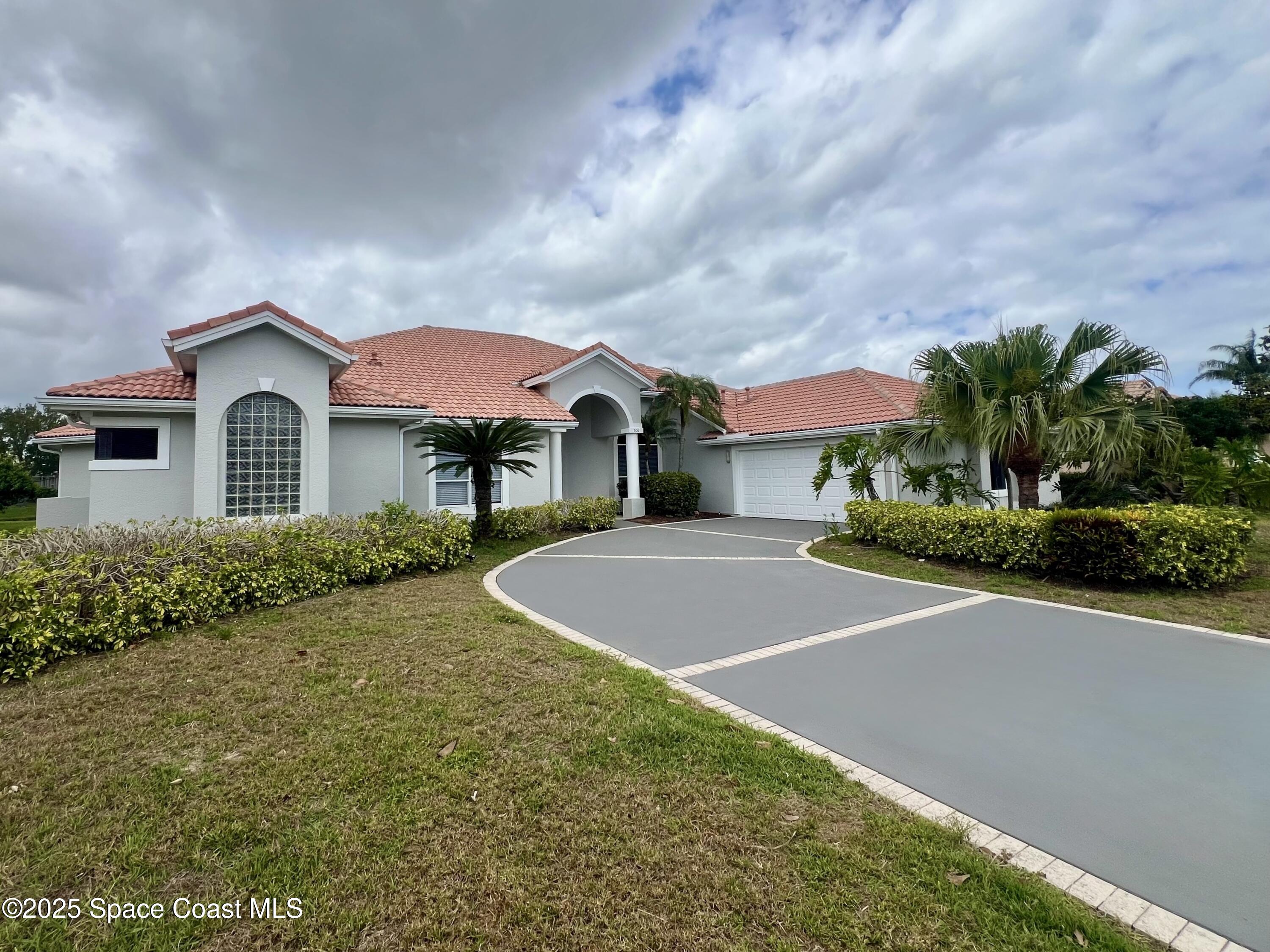 706 Palmer Way Melbourne, FL 32940 - Photo 3 of 43 a front view of a house with a yard and garage