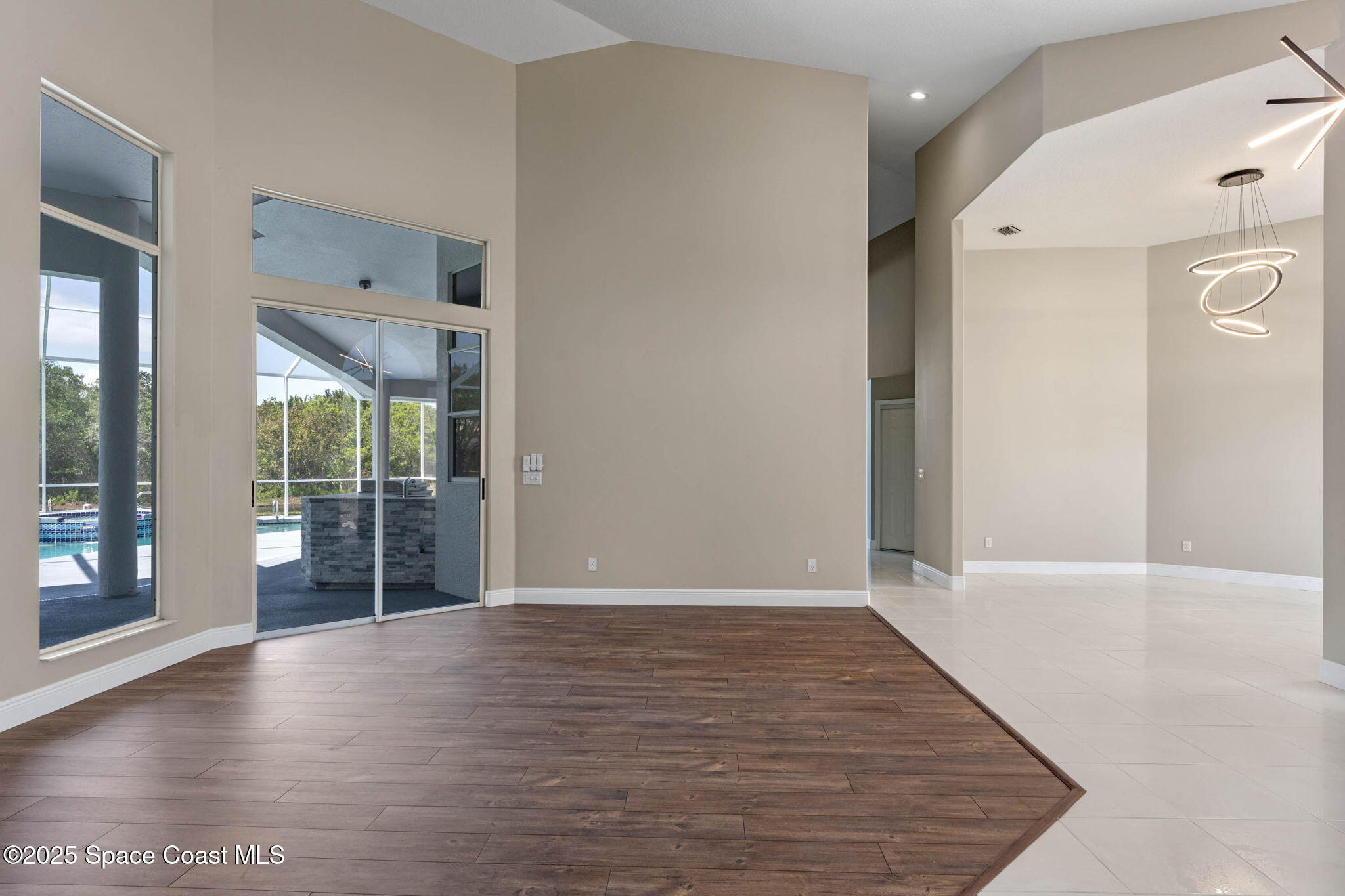 706 Palmer Way Melbourne, FL 32940 - Photo 9 of 43 a view of an empty room with wooden floor and a window