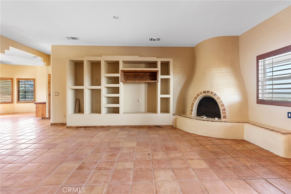 23032 Sky Mesa Road Homeland, CA 92548 - Photo 11 of 58 a view of an empty room with a fireplace and a window
