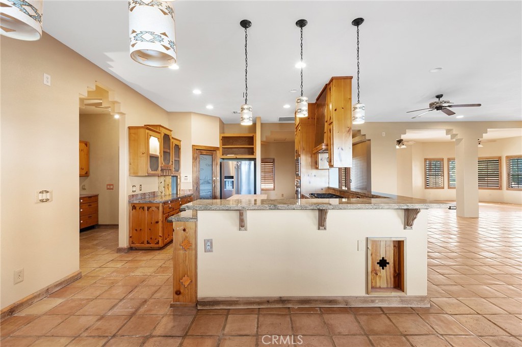 23032 Sky Mesa Road Homeland, CA 92548 - Photo 16 of 58 a view of a kitchen with kitchen island stainless steel appliances kitchen island granite countertop dining table chairs and a chandelier