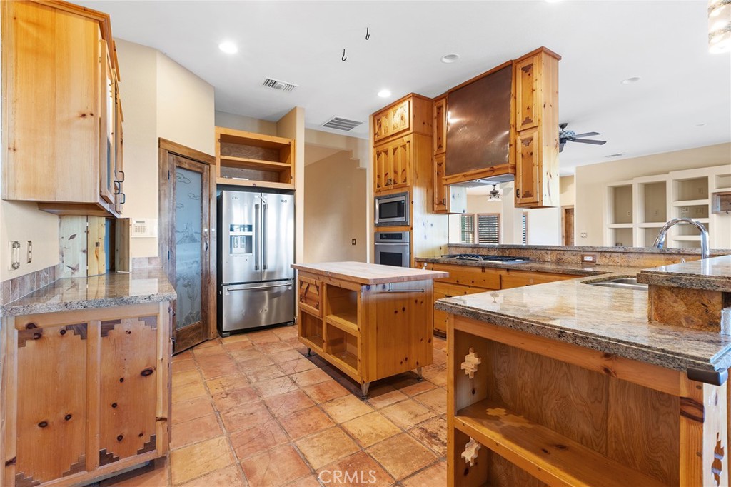 23032 Sky Mesa Road Homeland, CA 92548 - Photo 17 of 58 a kitchen with stainless steel appliances granite countertop a sink and a refrigerator