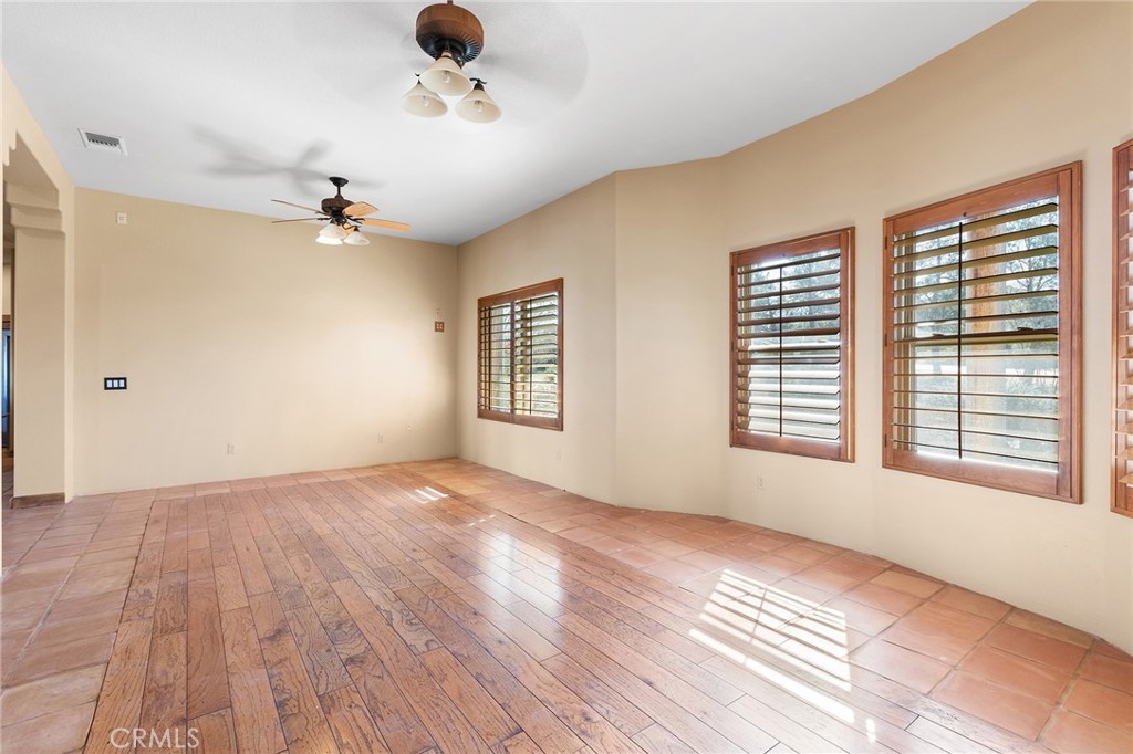 23032 Sky Mesa Road Homeland, CA 92548 - Photo 8 of 58 a view of an empty room with a window and wooden floor