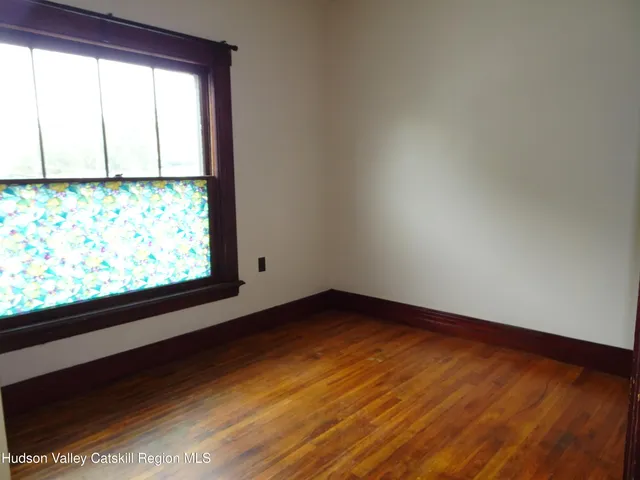 a view of a big room with wooden floor and windows