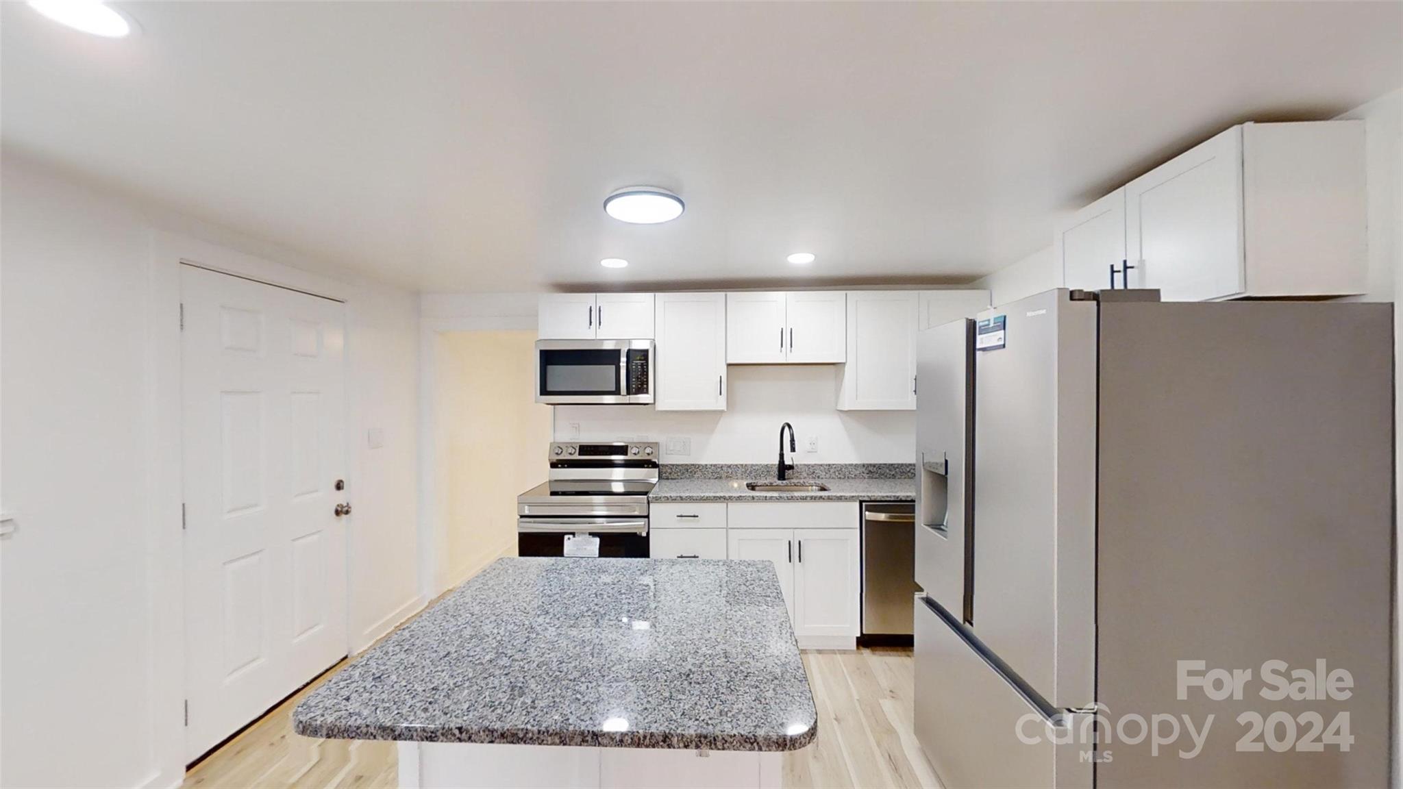 46 Lewis Street Canton, NC 28716 - Photo 11 of 27 a kitchen with stainless steel appliances granite countertop a refrigerator a stove and a sink