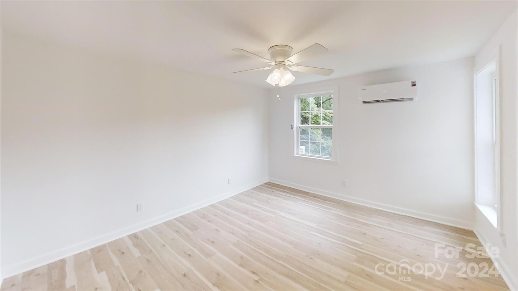 46 Lewis Street Canton, NC 28716 - Photo 14 of 27 an empty room with wooden floor chandelier fan and windows