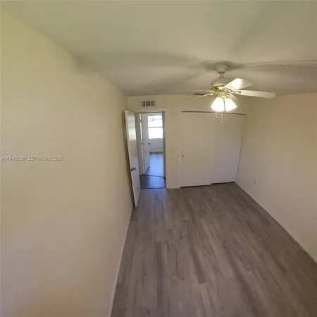 a view of a room with wooden floor and white walls