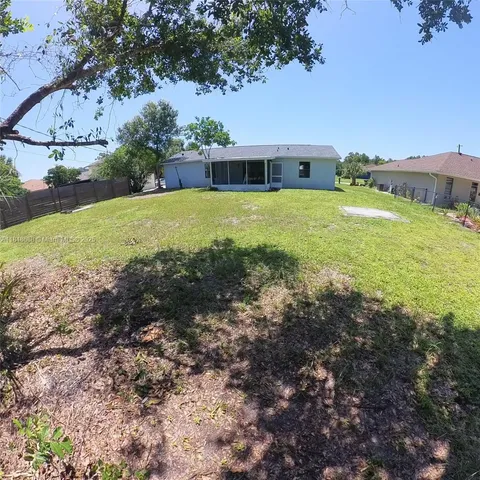 a view of a house with a big yard and large trees