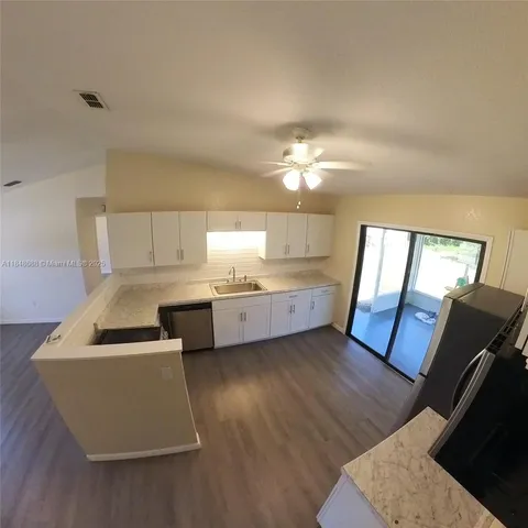 a view of kitchen with sink microwave and refrigerator