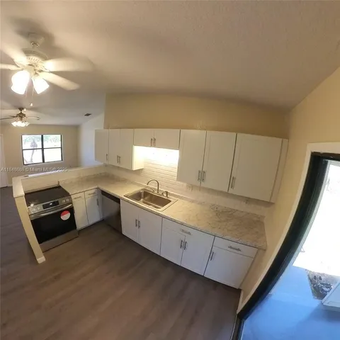 a kitchen with a stove a sink and a window
