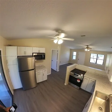 a kitchen with a refrigerator a stove top oven a counter space and a couch