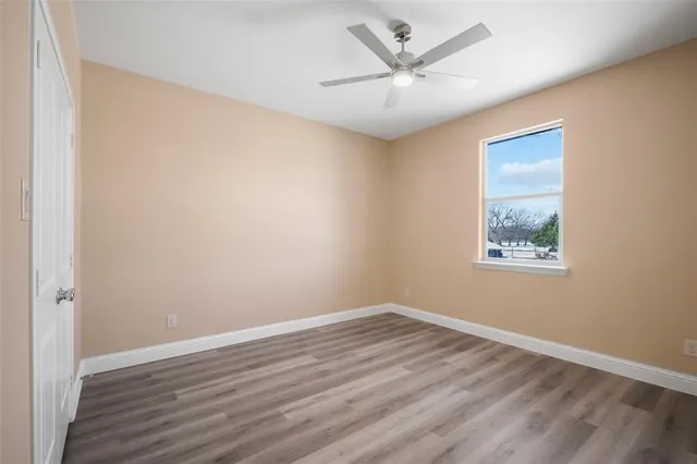 a view of a big room with wooden floor and windows