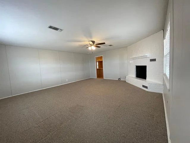 a view of a livingroom with a ceiling fan and window