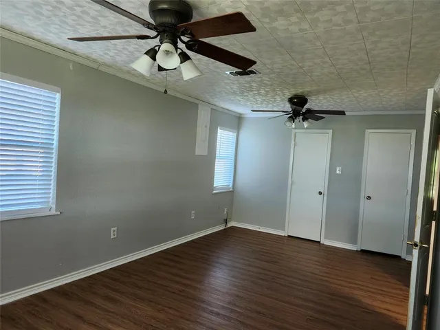 a view of room with hardwood floor and a ceiling fan