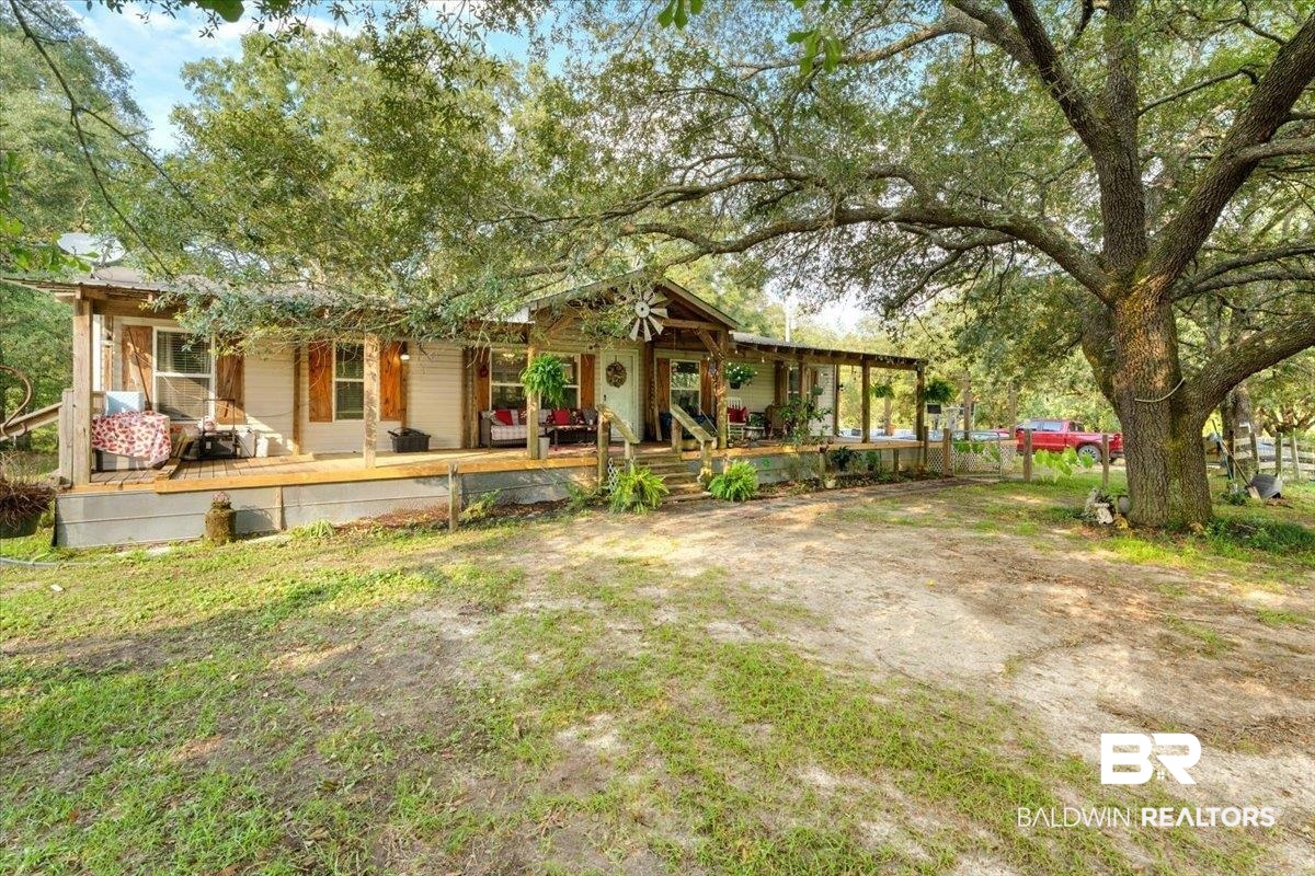 21011 River Road Robertsdale, AL 36567 - Photo 2 of 29 Ranch-style residence featuring a full-length covered porch, light-toned siding, and natural wood shutters