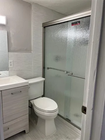 a white toilet sitting next to a shower