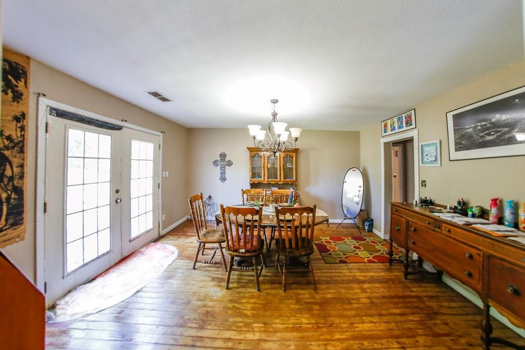6730 Pine Mill Road Reno, TX 75462 - Photo 12 of 21 Dining space with french doors, a chandelier, and wood-type flooring