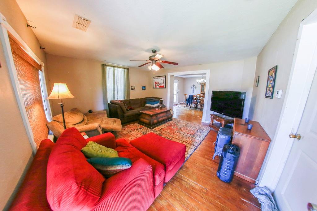 6730 Pine Mill Road Reno, TX 75462 - Photo 6 of 21 Living room featuring wood finished floors, ceiling fan, and a chandelier