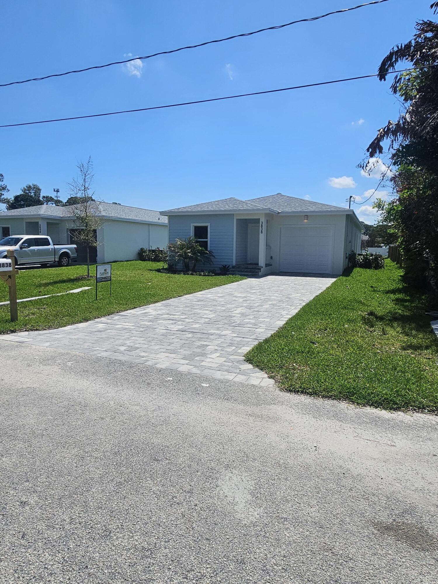 3838 Southeast Grant Street Stuart, FL 34997 - Photo 1 of 39 a view of a house with a yard and garage