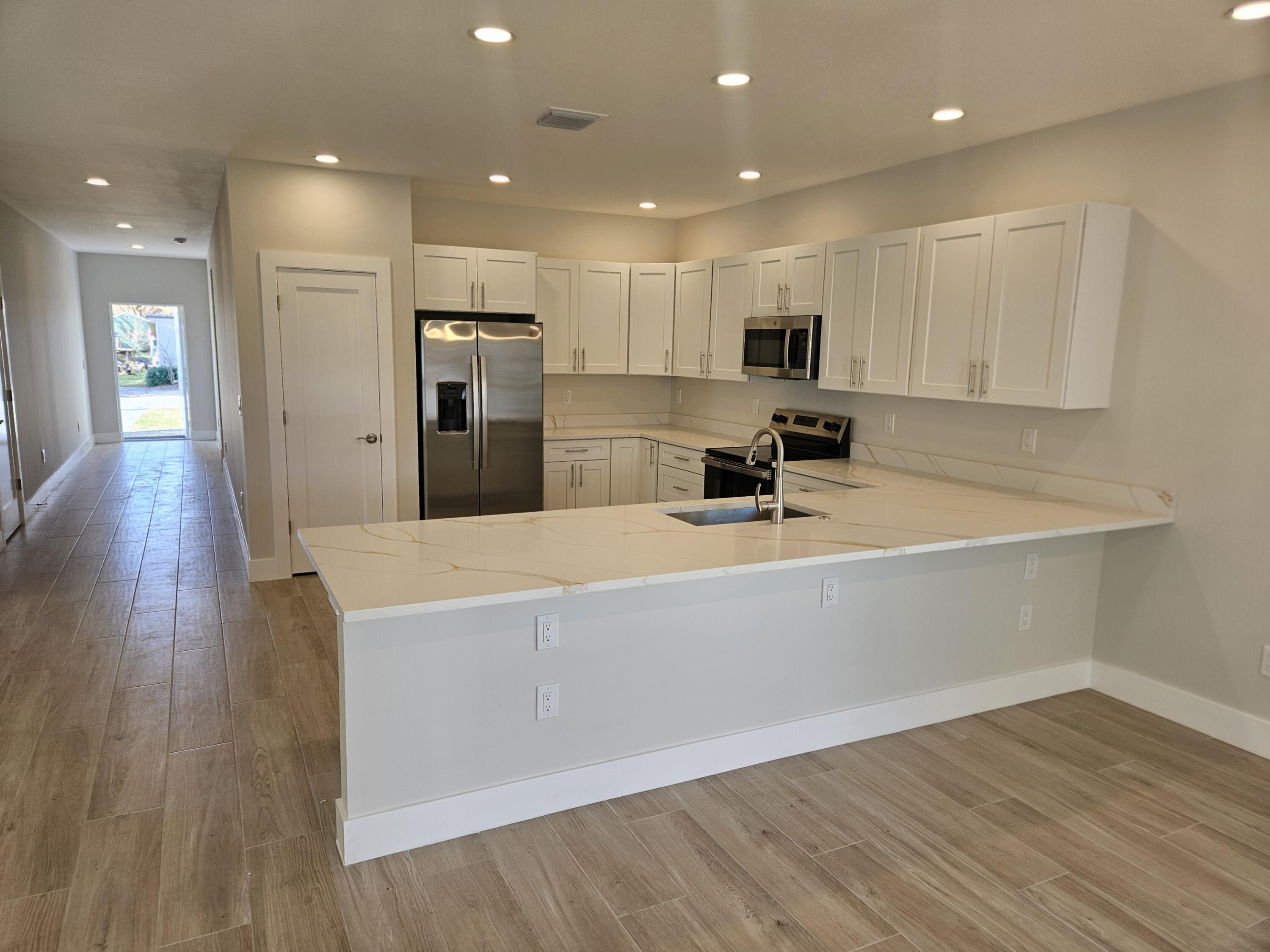 3838 Southeast Grant Street Stuart, FL 34997 - Photo 13 of 39 a view of kitchen with wooden floor and window