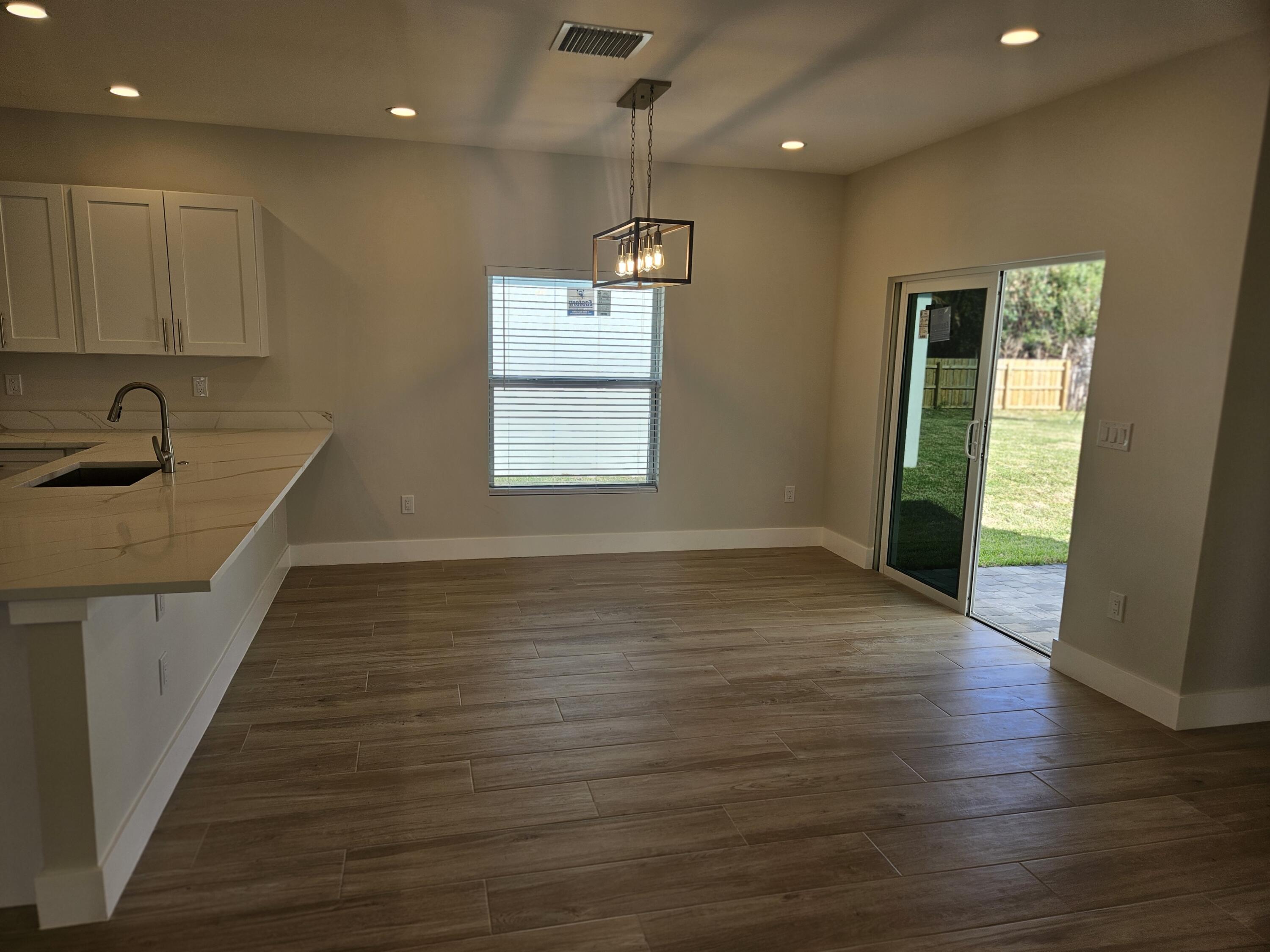 3838 Southeast Grant Street Stuart, FL 34997 - Photo 16 of 39 a view of an empty room with wooden floor and a window