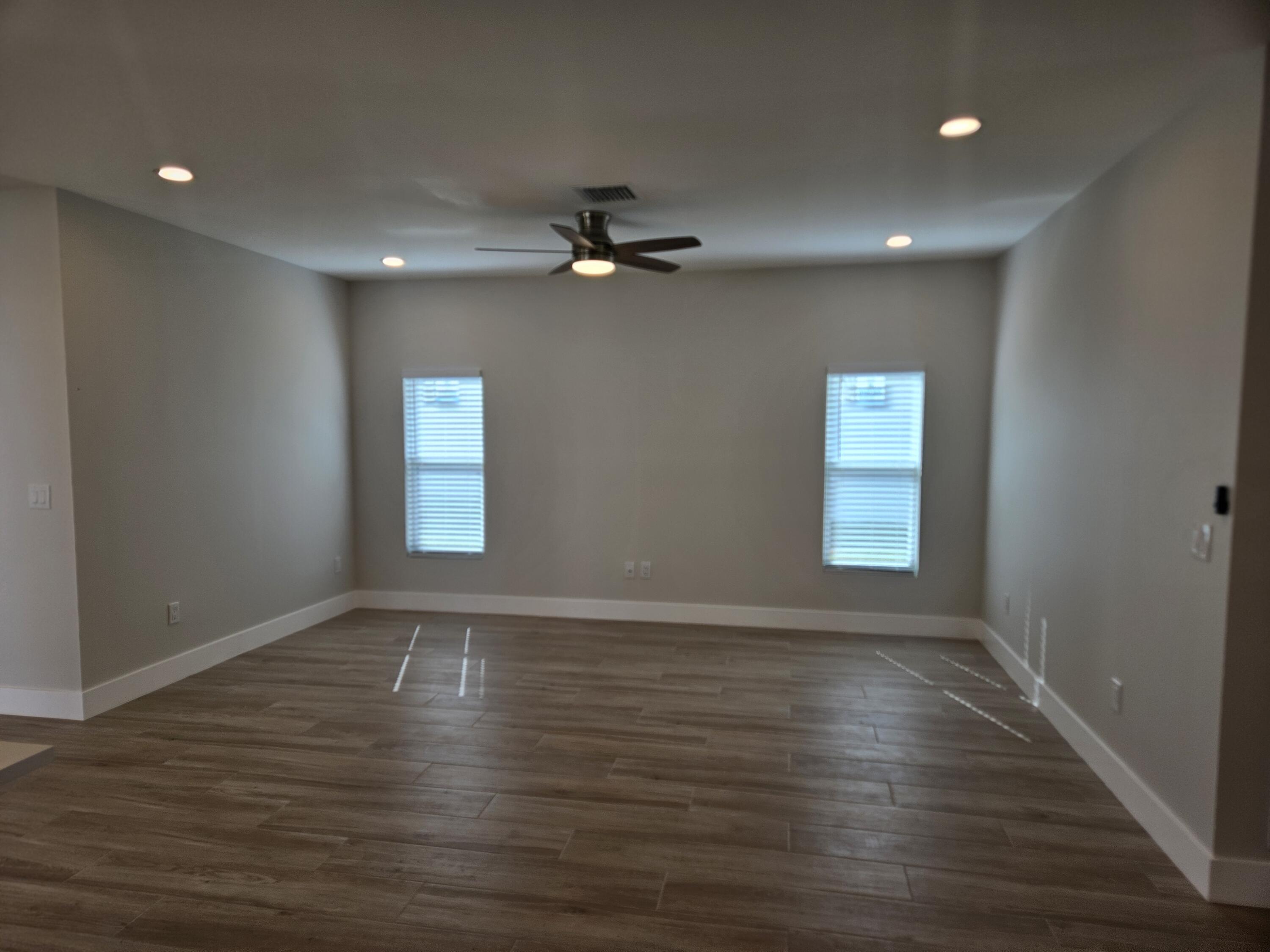 3838 Southeast Grant Street Stuart, FL 34997 - Photo 18 of 39 a view of an empty room with a window and wooden floor