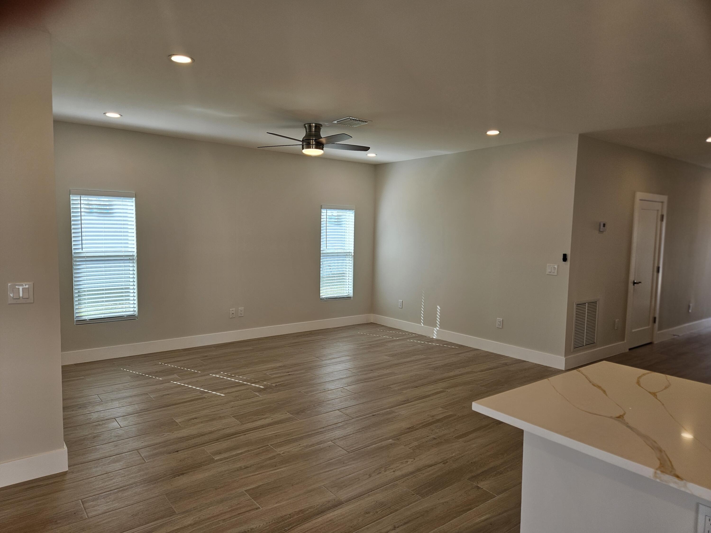3838 Southeast Grant Street Stuart, FL 34997 - Photo 19 of 39 a view of empty room with wooden floor and fan