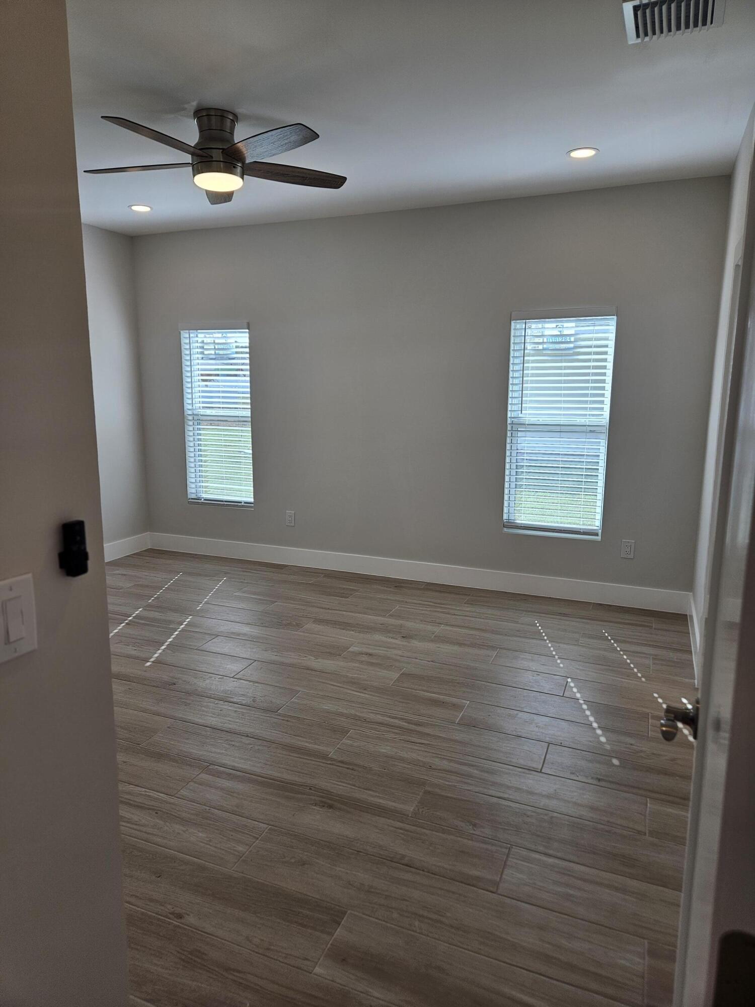3838 Southeast Grant Street Stuart, FL 34997 - Photo 20 of 39 an empty room with wooden floor and windows