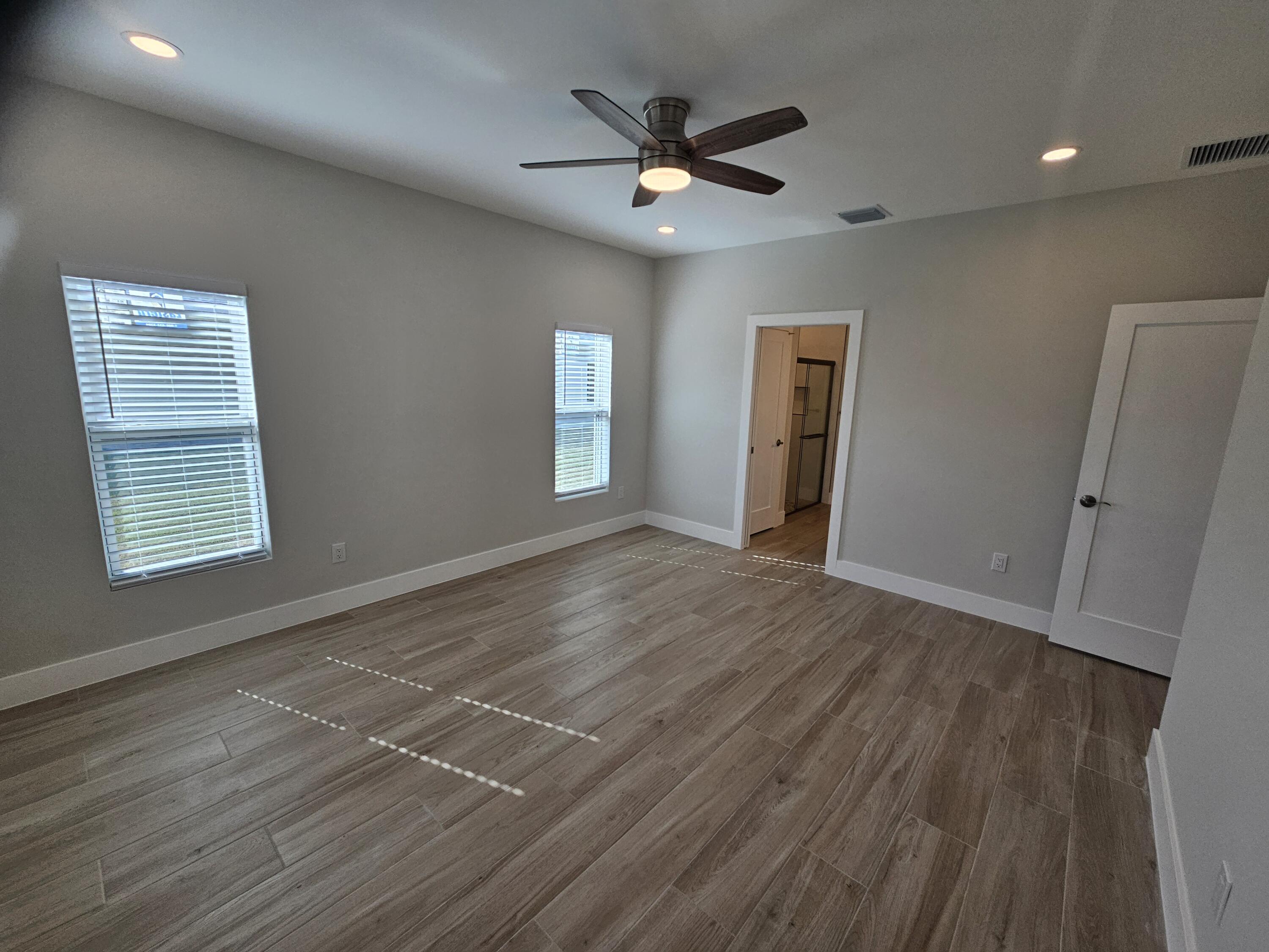 3838 Southeast Grant Street Stuart, FL 34997 - Photo 23 of 39 a view of an empty room with wooden floor and a window