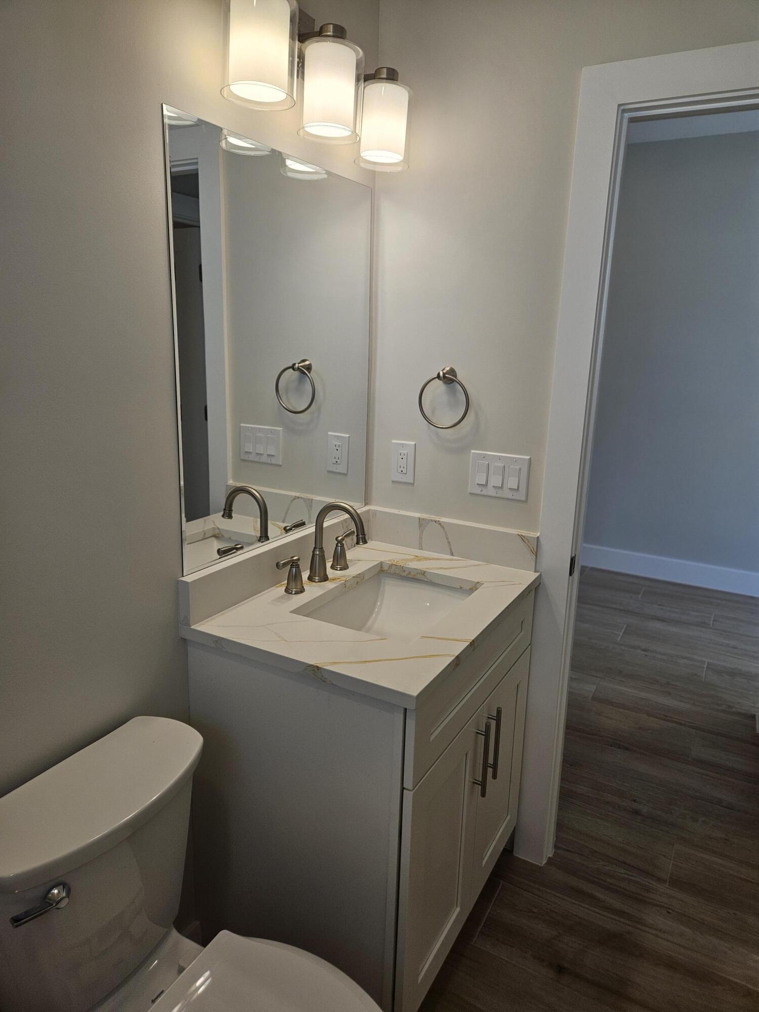 3838 Southeast Grant Street Stuart, FL 34997 - Photo 34 of 39 a bathroom with a sink a toilet and mirror
