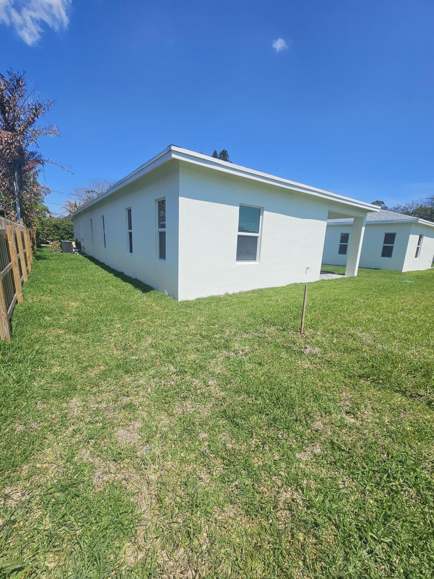 3838 Southeast Grant Street Stuart, FL 34997 - Photo 5 of 39 a backyard of a house with large trees and plants