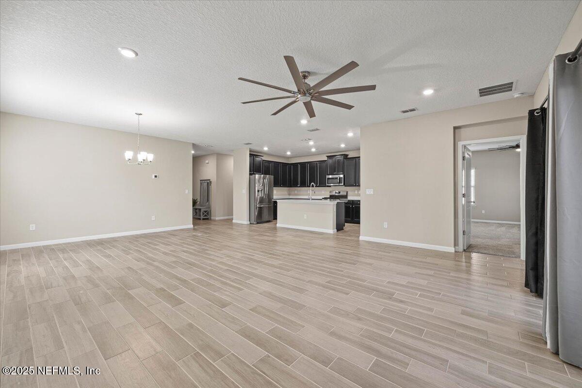 1728 Amberly Drive Middleburg, FL 32068 - Photo 8 of 32 a view of a big room with wooden floor and a ceiling fan