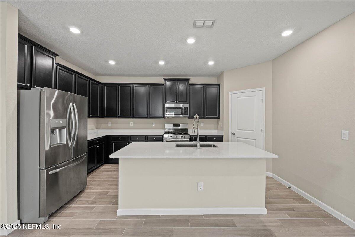 1728 Amberly Drive Middleburg, FL 32068 - Photo 10 of 32 a view of a kitchen with kitchen island a counter top space stainless steel appliances and cabinets