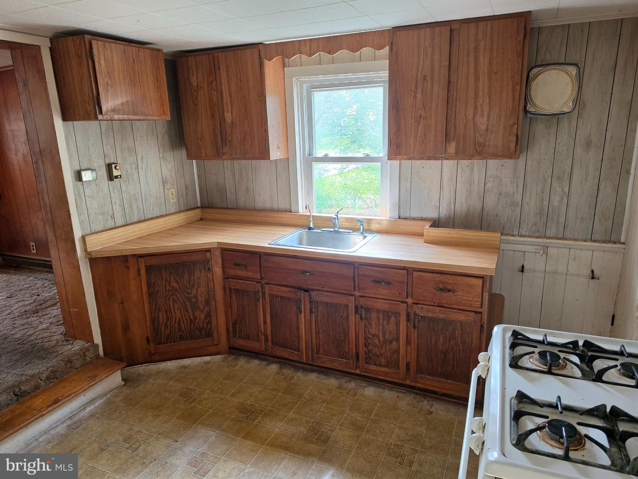 6018 Conover Road Taneytown, MD 21787 - Photo 9 of 18 a kitchen with a sink and wooden cabinets