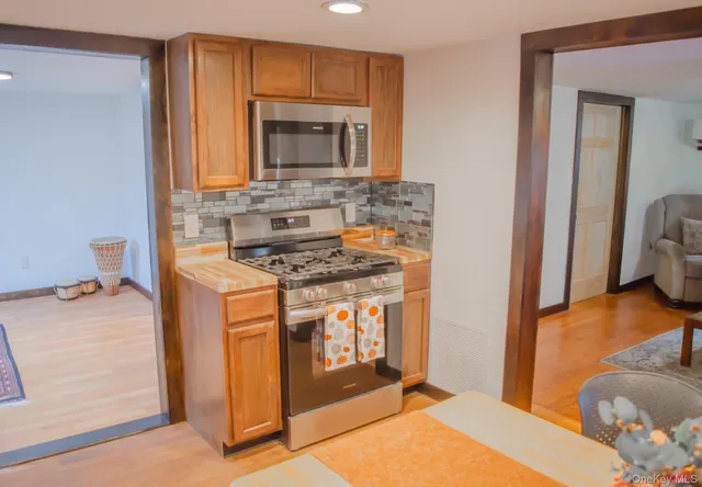 a kitchen with stainless steel appliances granite countertop a stove a sink and a microwave