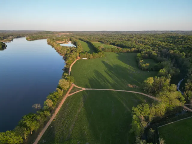 an aerial view of ocean and residential houses with outdoor space