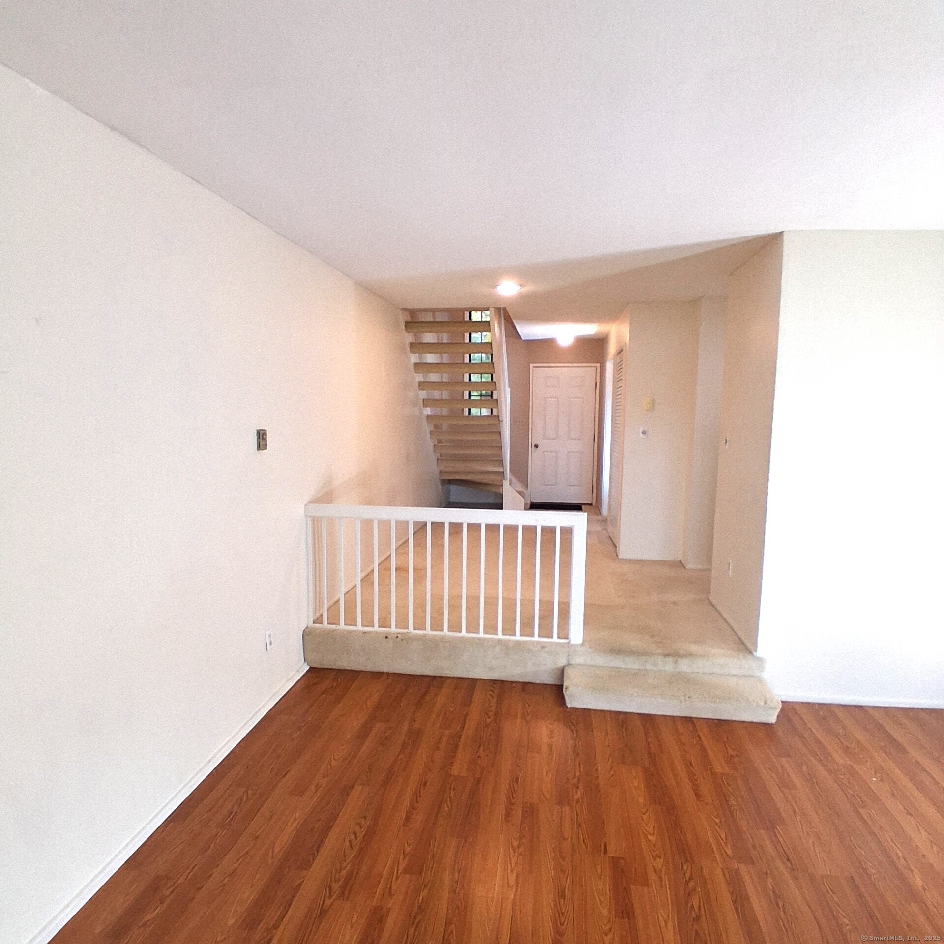 a view of a room with wooden floor