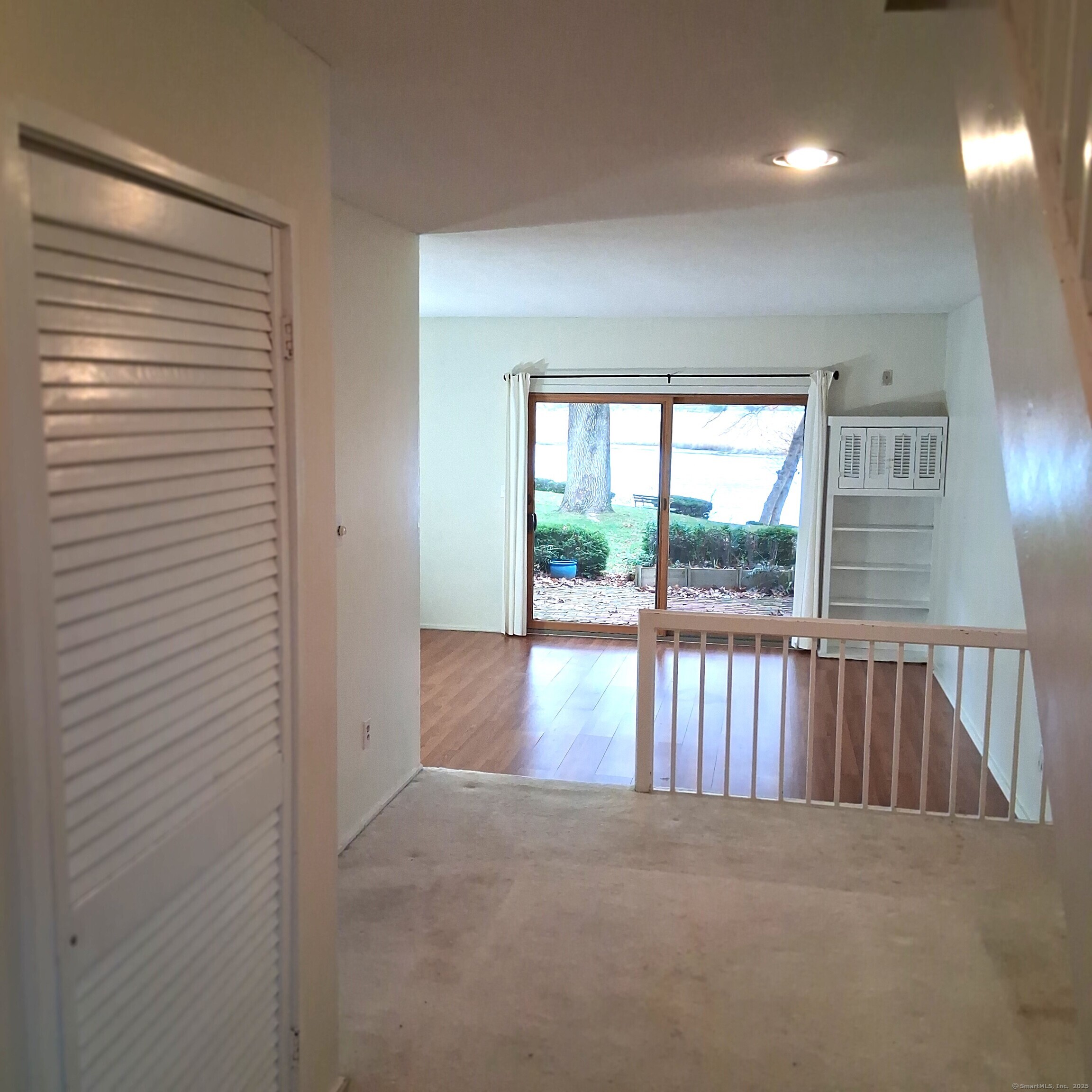 85 River Road, Unit B7 Essex, CT 06426 - Photo 7 of 23 a view of an empty room with wooden floor and a window