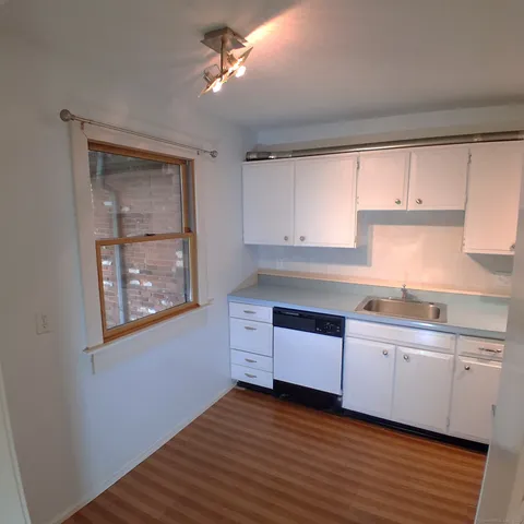 a kitchen with granite countertop a stove a sink and cabinets