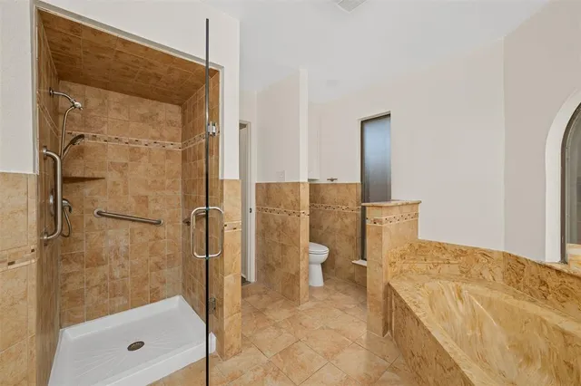 a bathroom with a granite countertop shower a toilet and a sink
