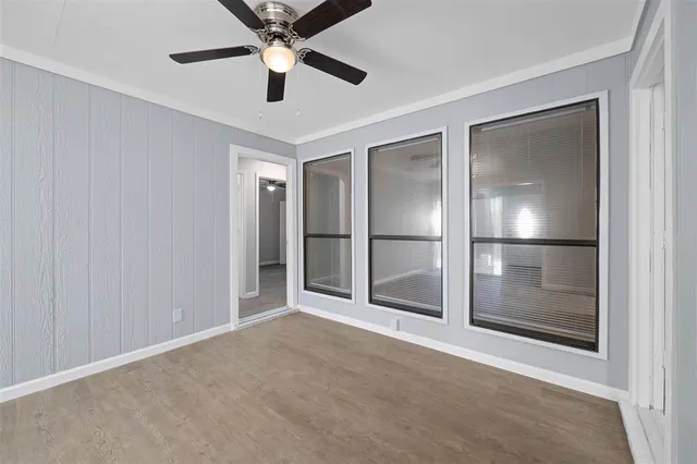 a view of empty room with wooden floor and window