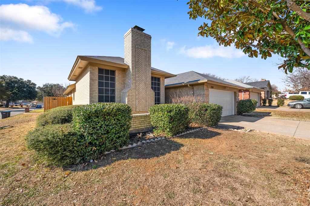 720 Sandy Trail Fort Worth, TX 76120 - Photo 2 of 24 a front view of a house with a yard and potted plants
