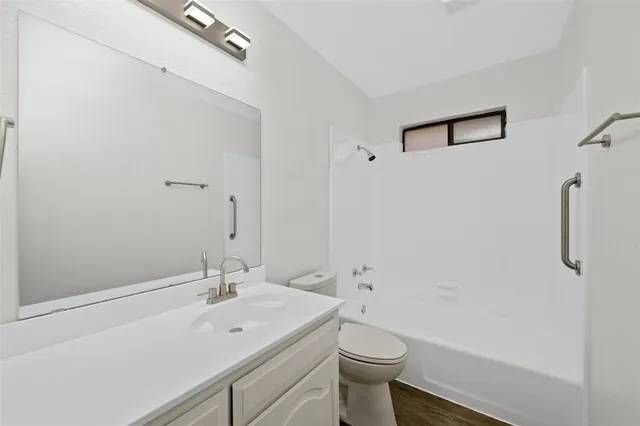 an empty room with ceiling fan and windows