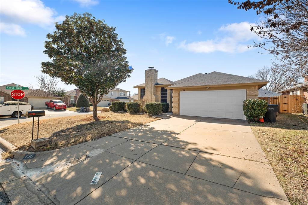 720 Sandy Trail Fort Worth, TX 76120 - Photo 4 of 26 a front view of a house with a yard and garage