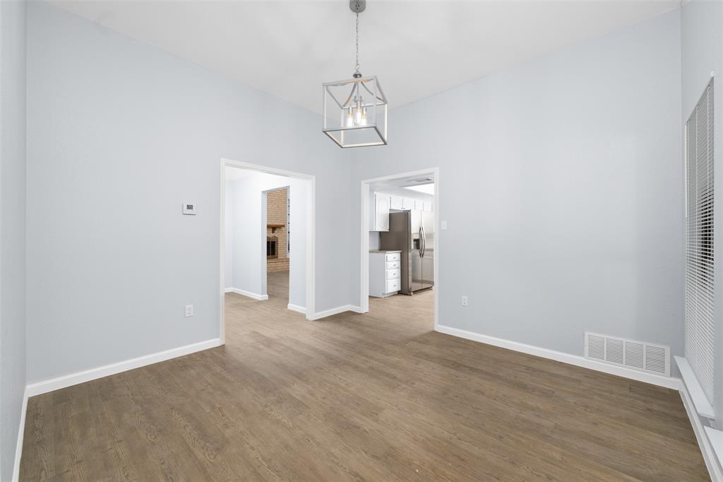 720 Sandy Trail Fort Worth, TX 76120 - Photo 9 of 24 a view of empty room with wooden floor and kitchen