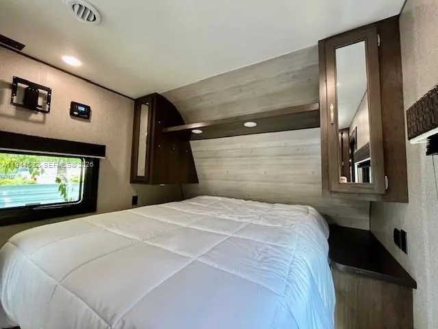 a bedroom with a bed and a large mirror