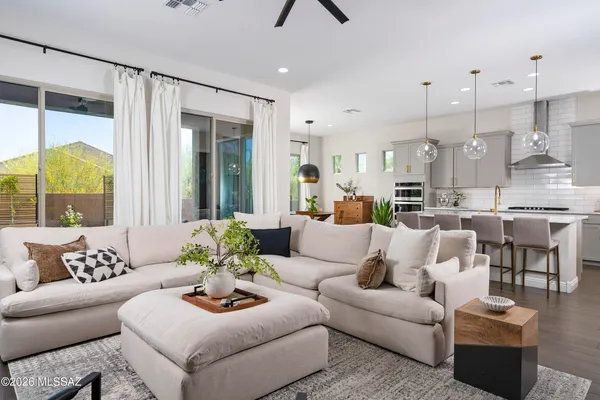 a living room with furniture kitchen view and a large window