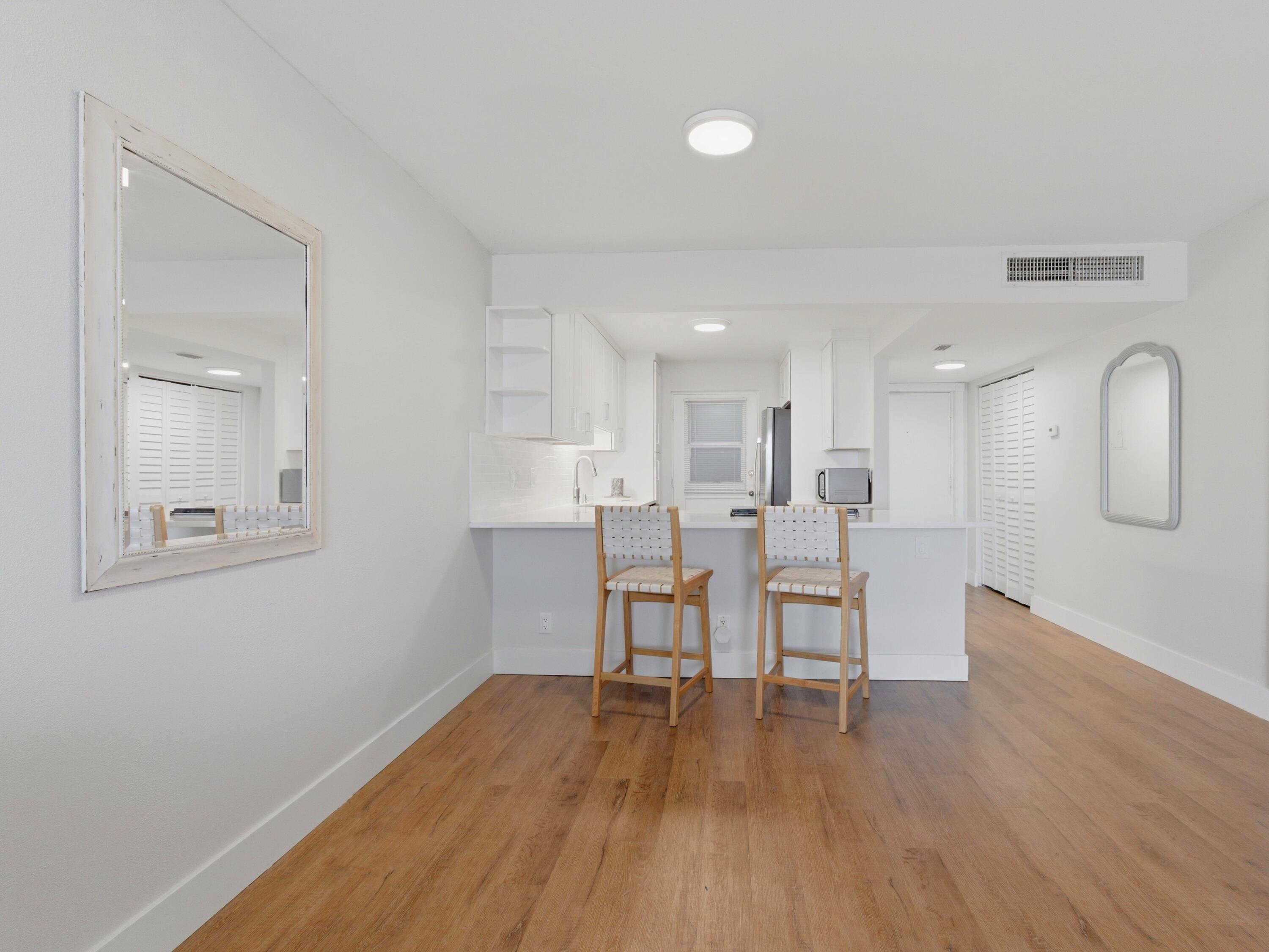 5500 Northwest 2nd Avenue, Unit 519 Boca Raton, FL 33487 - Photo 12 of 48 a view of a dining room with furniture and wooden floor