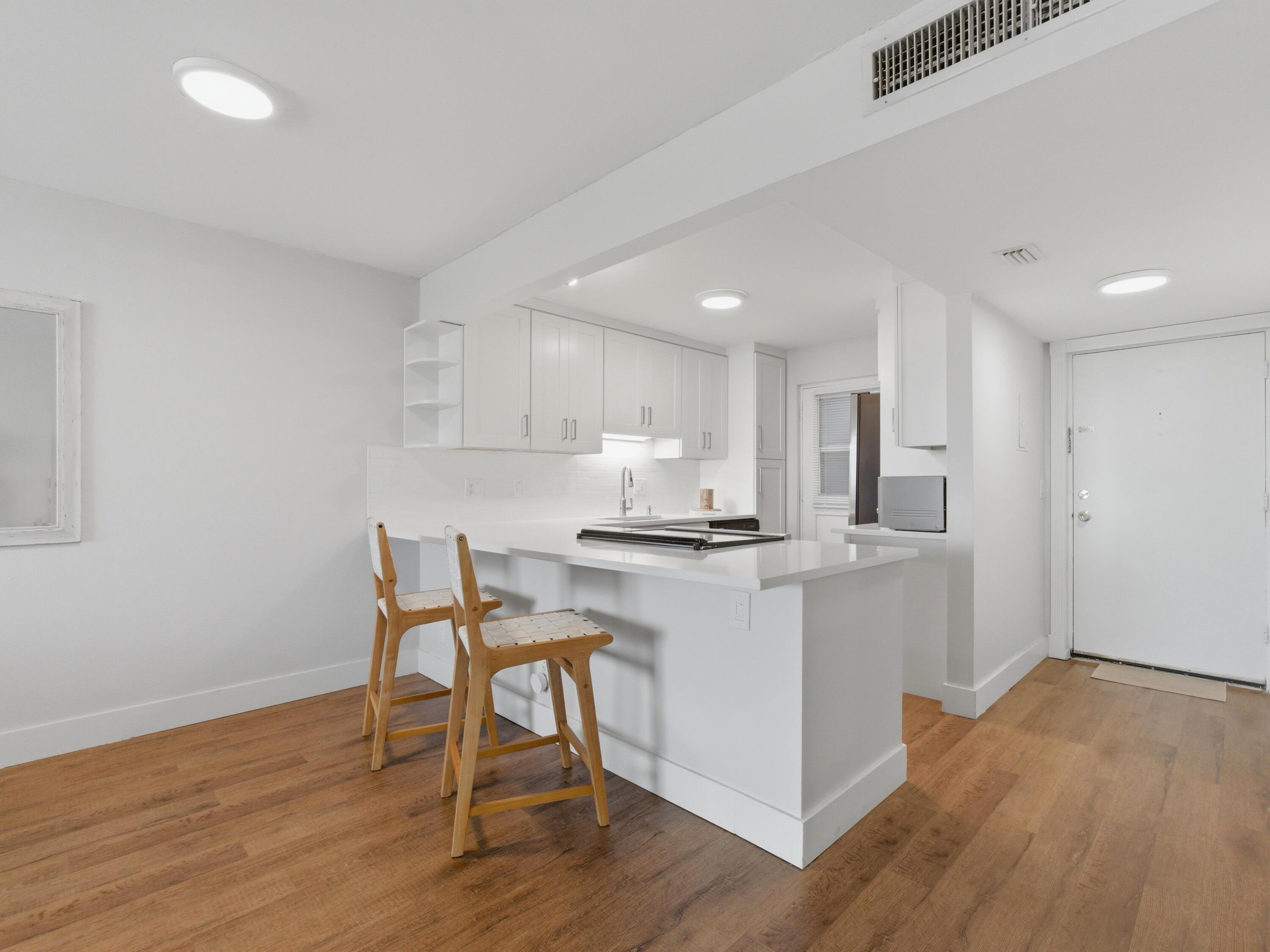 5500 Northwest 2nd Avenue, Unit 519 Boca Raton, FL 33487 - Photo 4 of 48 a kitchen with stainless steel appliances granite countertop a white cabinets and wooden floor