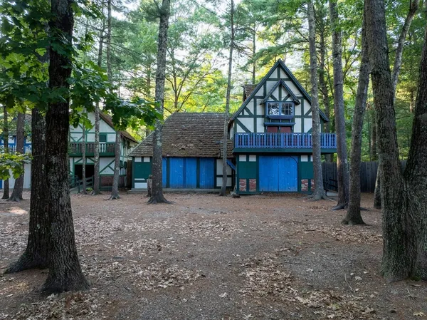 a front view of a house with a yard and tree s