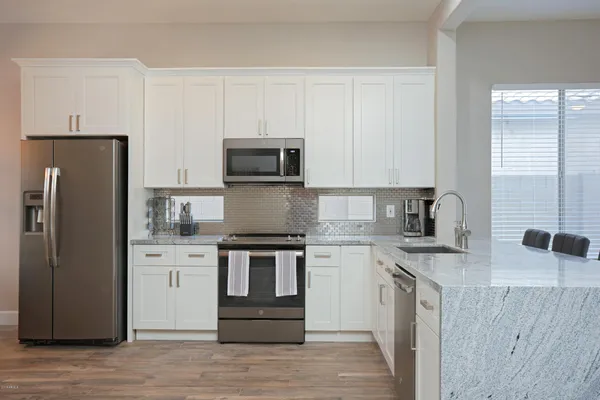 a kitchen with stainless steel appliances granite countertop a refrigerator stove and sink